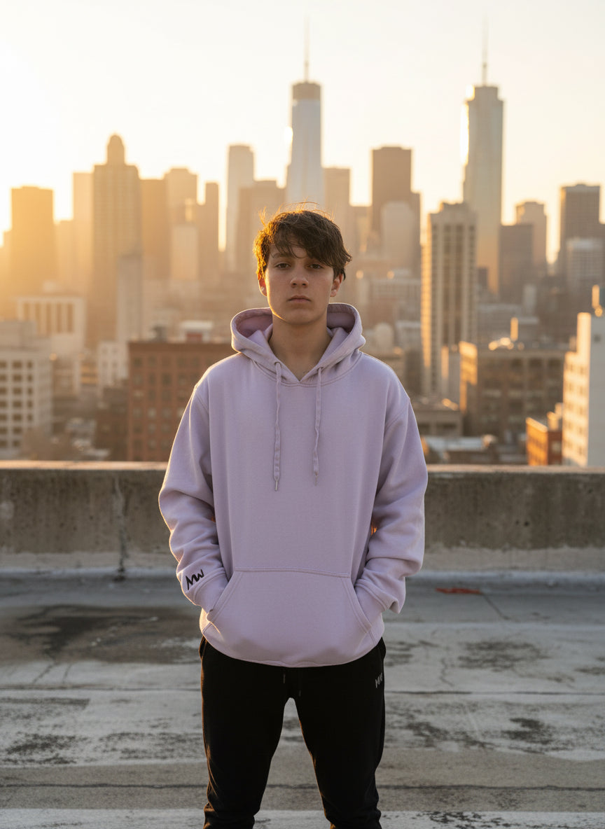 Person wearing a light purple hoodie with a logo on a plain background