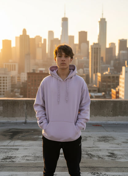 Person wearing a light purple hoodie with a logo on a plain background