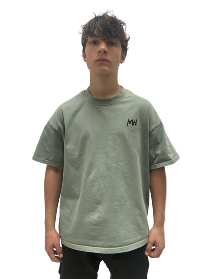 Trendy streetwear Person wearing a green t-shirt with a logo on a plain background