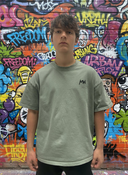 Trending streetwear Person wearing a green t-shirt with a logo on a plain background