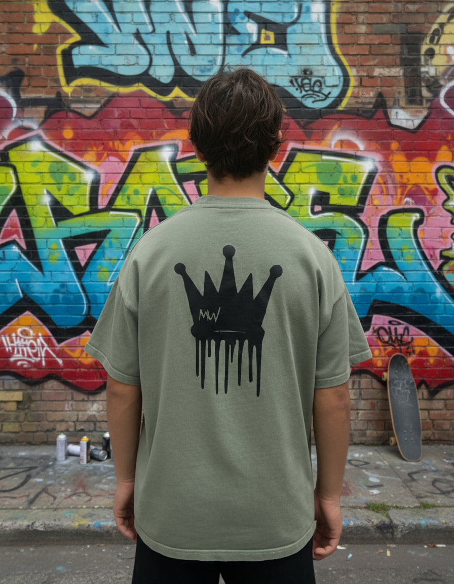Trending streetwear Person wearing a green t-shirt with a black crown design on the back against a plain background