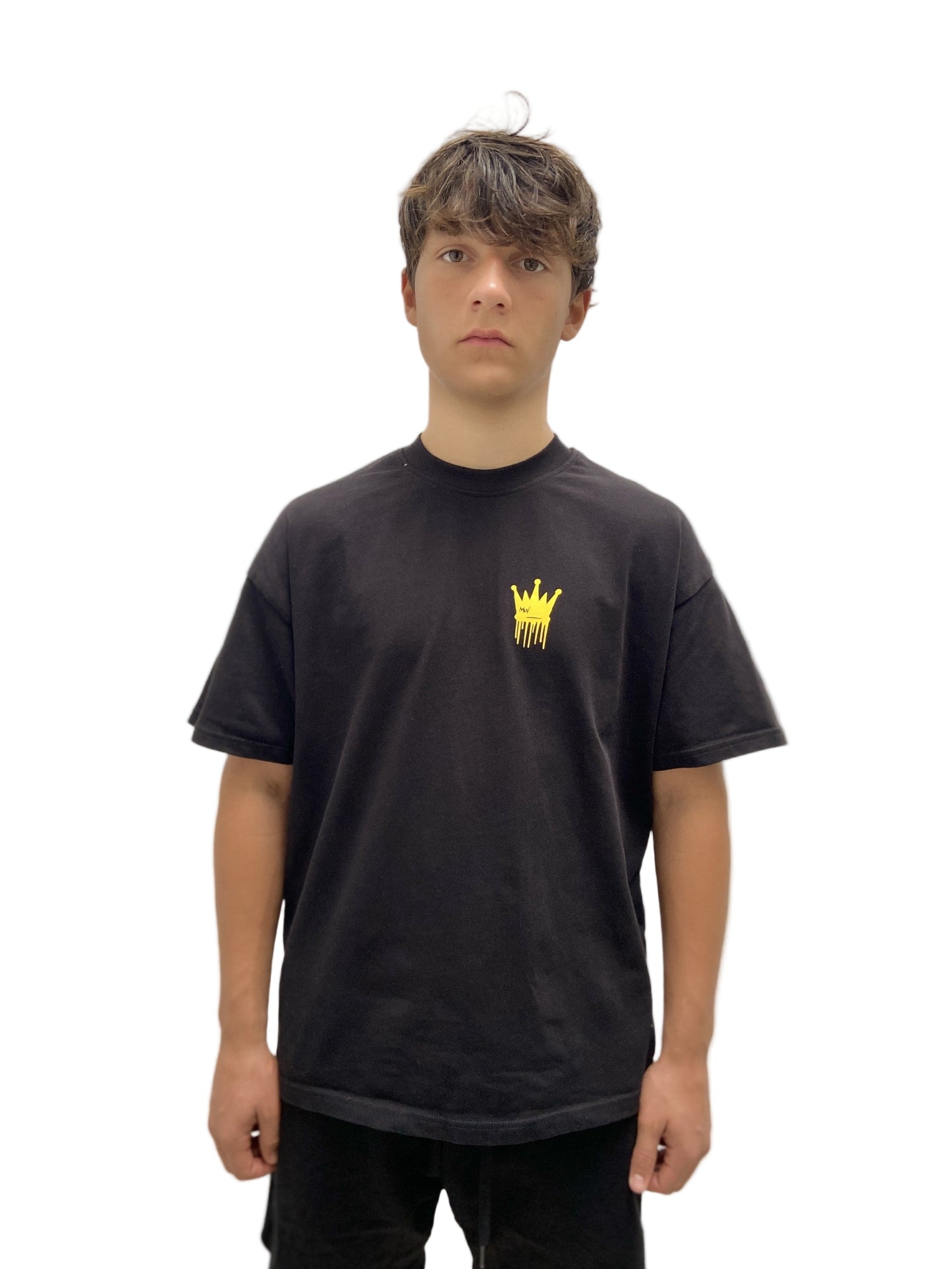 Person wearing a black t-shirt with a yellow logo on a plain background