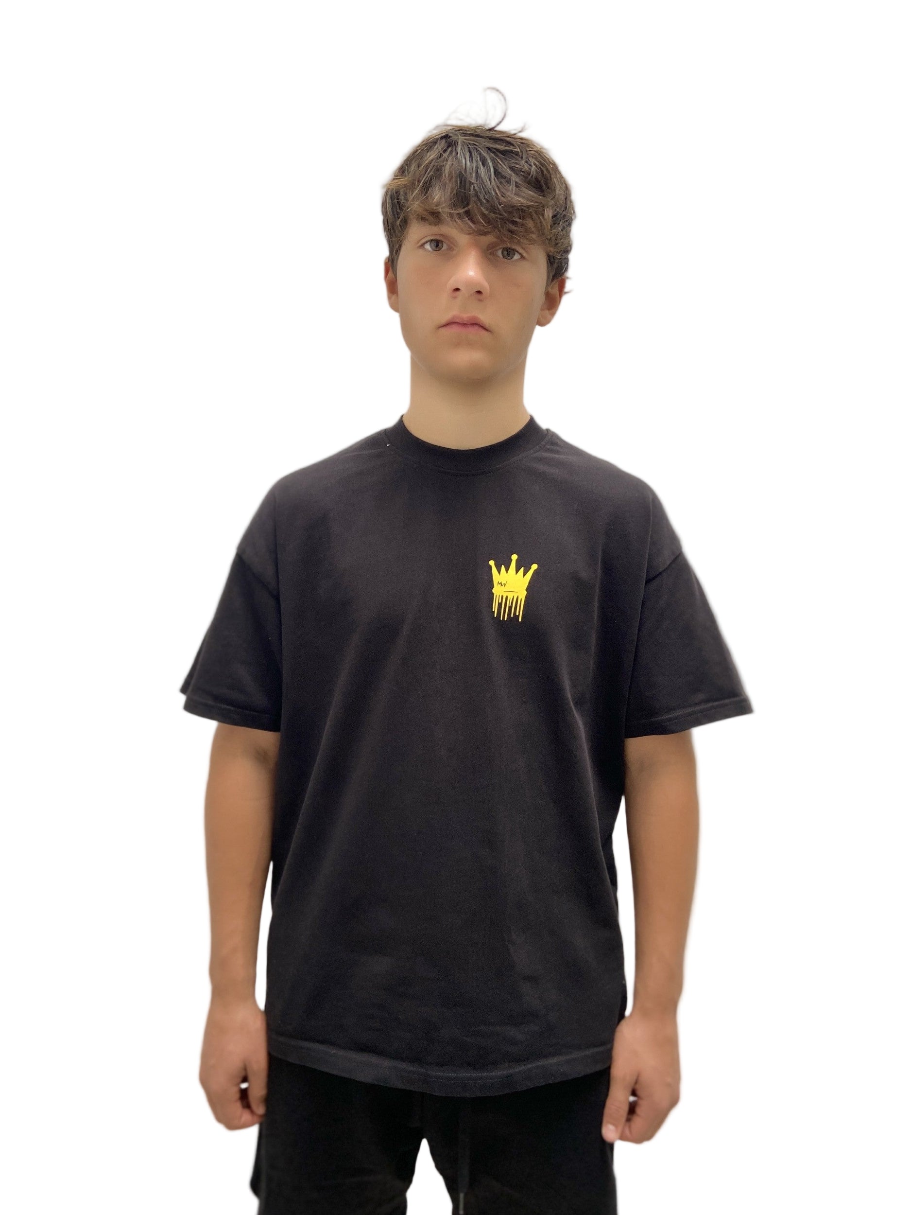 Person wearing a black t-shirt with a yellow logo on a plain background