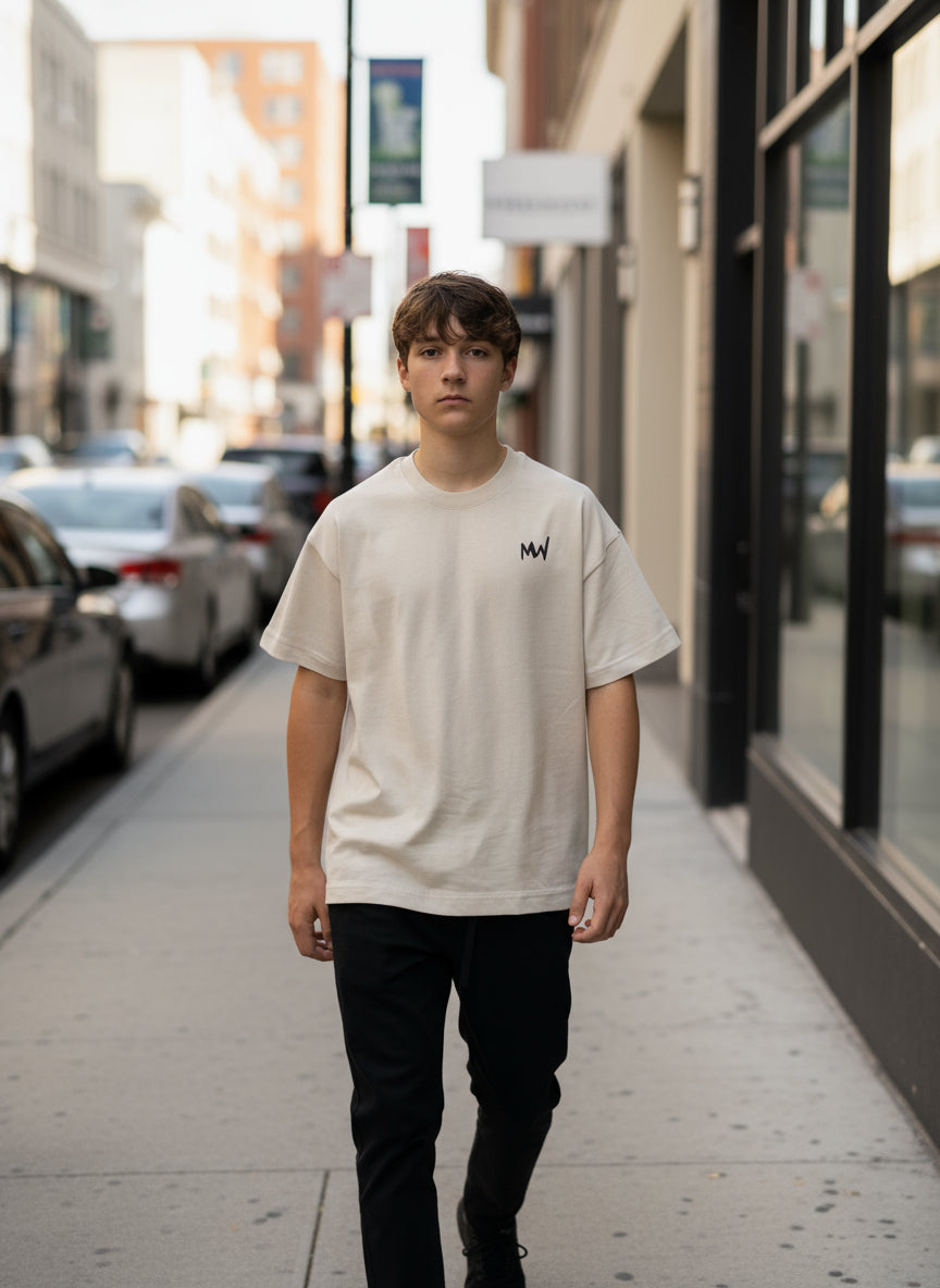 Trending streetwear Person wearing a beige t-shirt with a logo on a plain background