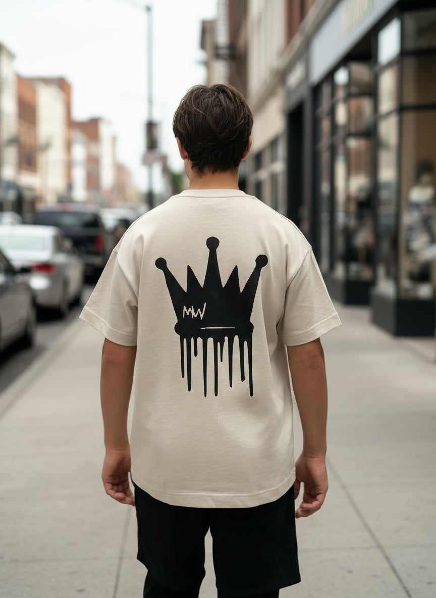 trending streetwear Person wearing a beige t-shirt with a black crown graphic on the back against a plain background